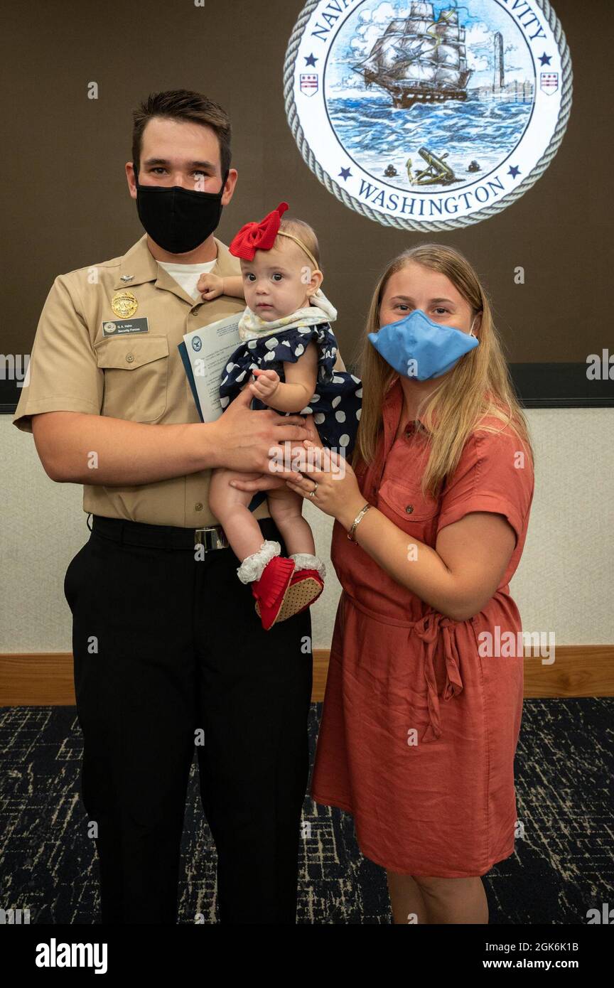 WASHINGTON, DC (Aug. 16, 2021) – Master-at-Arms 2nd Class Griffin Hahn, left, poses with his family during an award ceremony held onboard Washington Navy Yard. Stock Photo