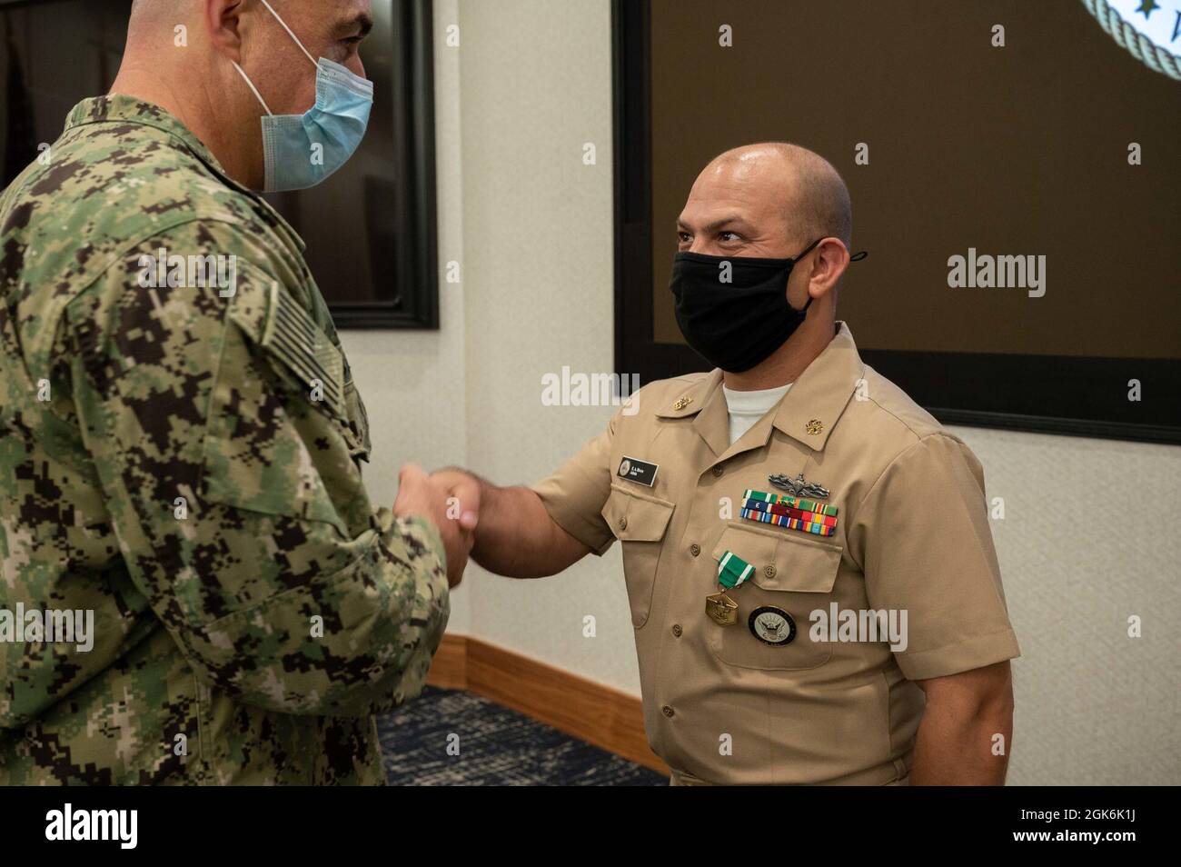 WASHINGTON, DC (Aug. 16, 2021) – Capt. Mark Burns (left), Naval Support Activity Washington commanding officer, presents Chief Navy Counselor Eduardo Rivera (right) with a Navy and Marine Corps commendation medal during an award ceremony held onboard Washington Navy Yard. Stock Photo