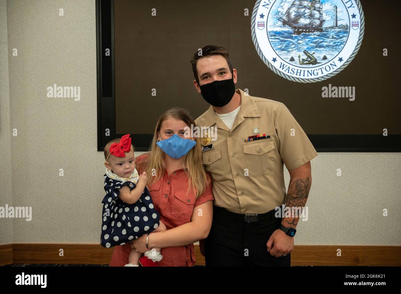 WASHINGTON, DC (Aug. 16, 2021) – Master-at-Arms 3rd Class Griffin Hahn, right, poses with family members before an award ceremony held onboard Washington Navy Yard. Stock Photo