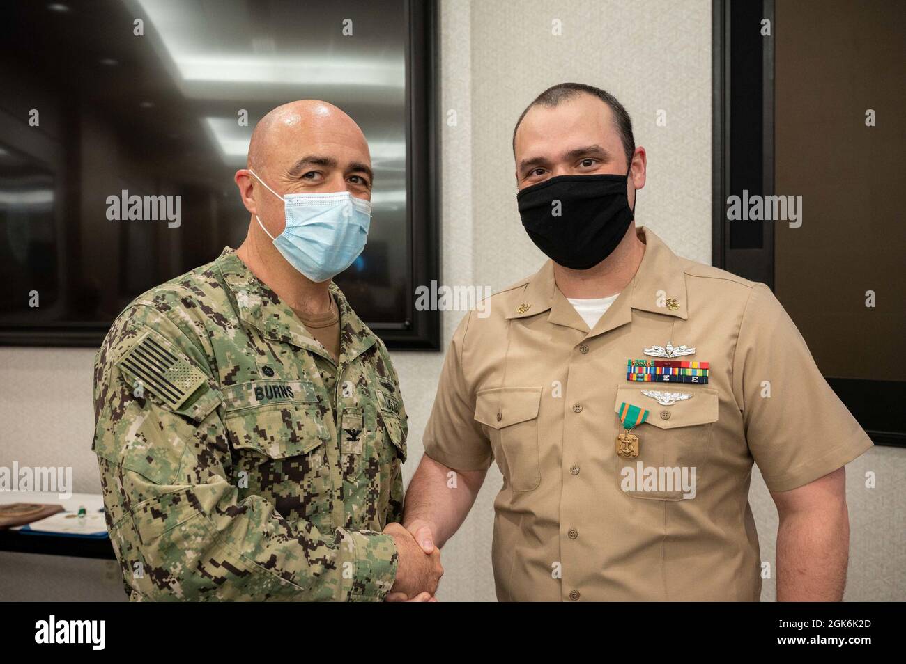 WASHINGTON, DC (Aug. 16, 2021) – Capt. Mark Burns (left), Naval Support Activity Washington commanding officer, presents Chief Fire Controlman Kyle Gregory (right) with a Navy and Marine Corps achievement medal during an award ceremony held onboard Washington Navy Yard. Stock Photo