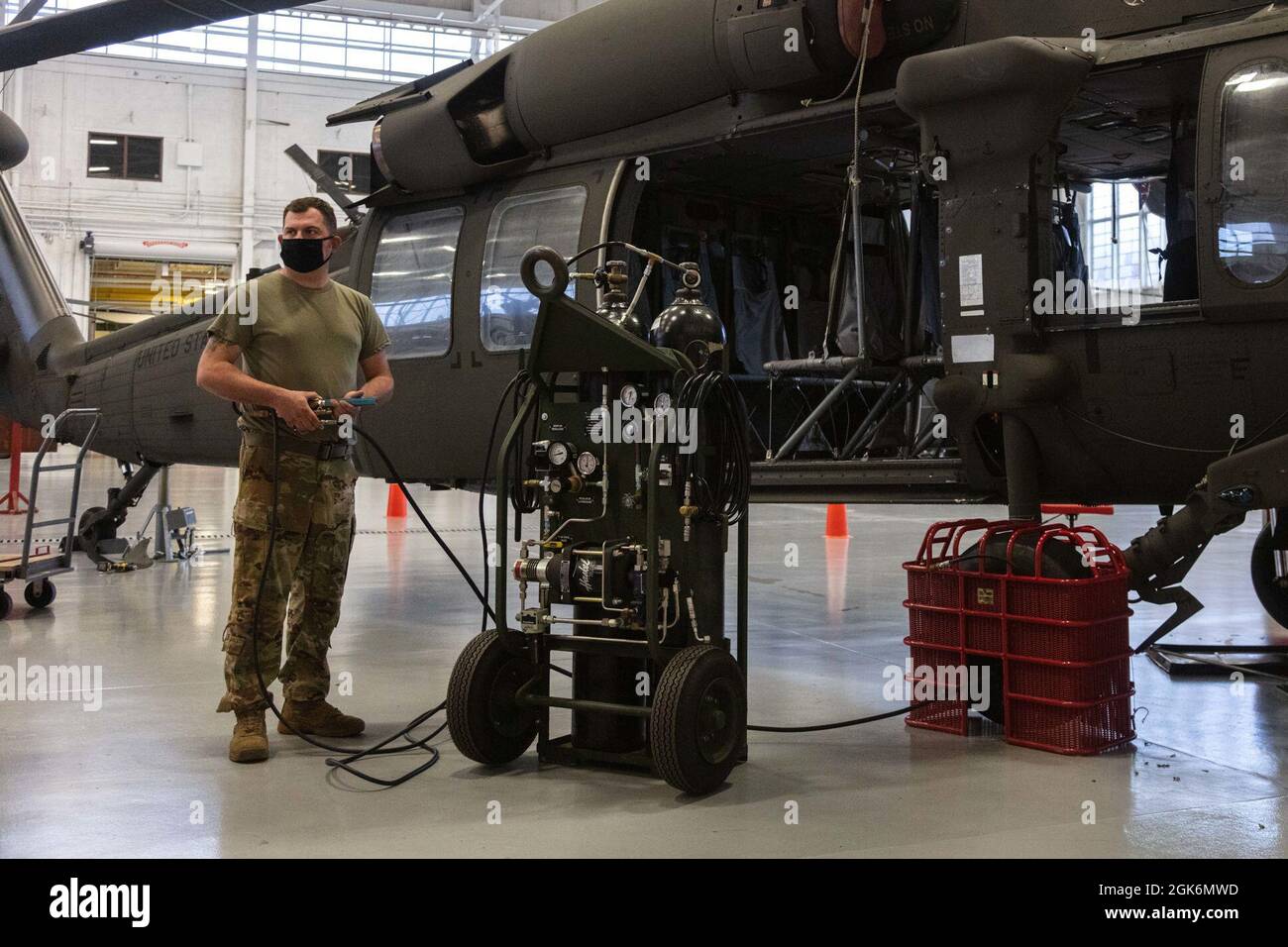 U.S. Army Sgt. Kris Whitworth, an aircraft mechanic with Alpha Company 1st General Support Aviation Battalion 171st Aviation Regiment, Georgia Army National Guard, inflates the tire of a Black Hawk helicopter during routine maintenance at Clay National Guard Center in Marietta, Georgia. Georgia Army National Guard aviation units are among the most frequently deployed in the state and region supporting multiple training exercises with the Georgia National Guard, as well as emergency response missions at such as hurricane relief operations, COVID-19 pandemic and supporting overseas combat missio Stock Photo