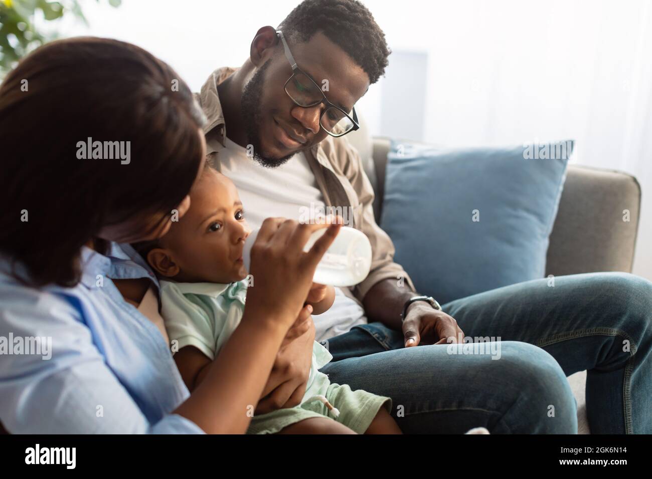 African American man feeding baby son bottle Stock Photo - Alamy