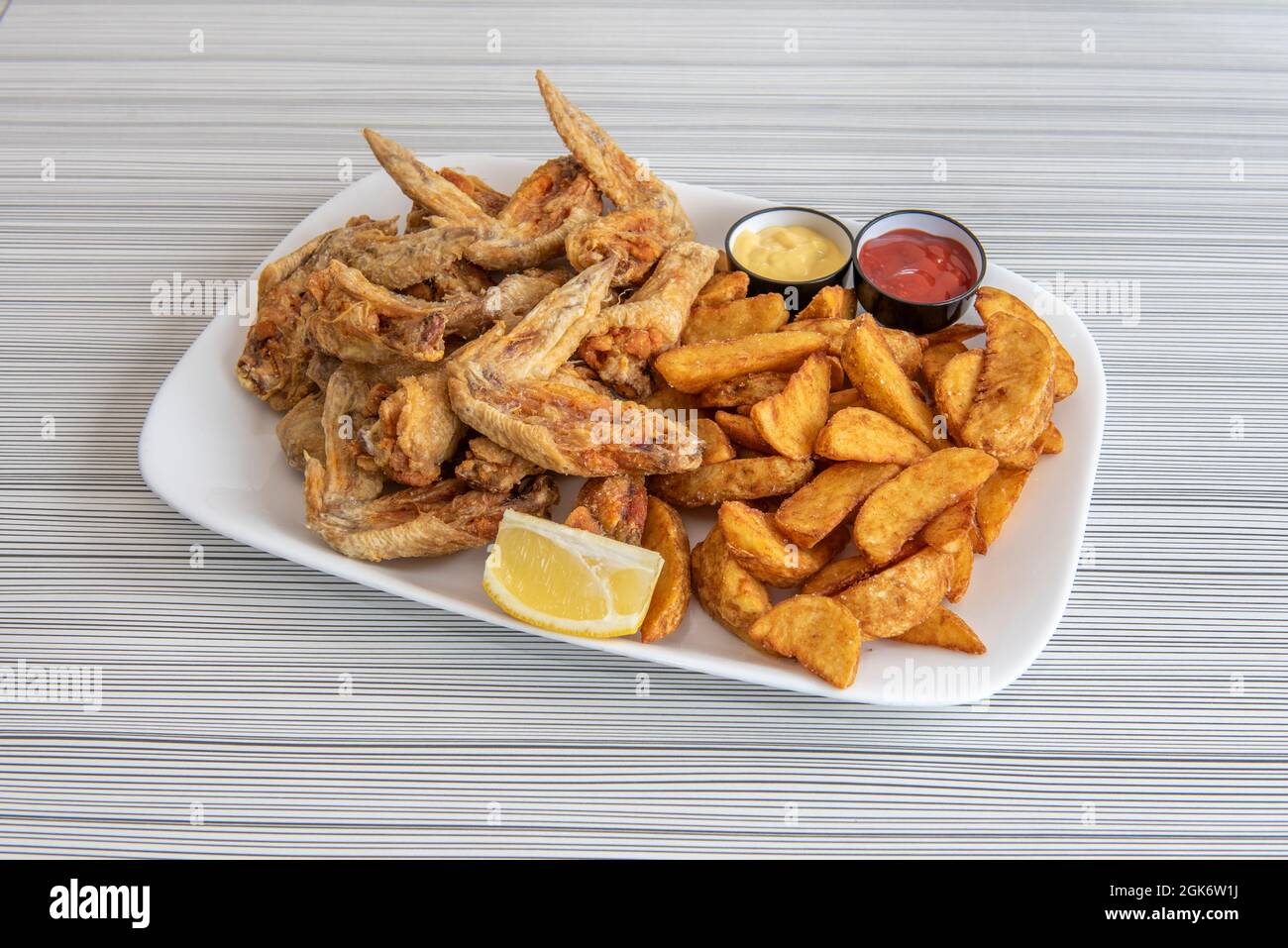 Large portion of olive oil fried wings garnished with fancy fries