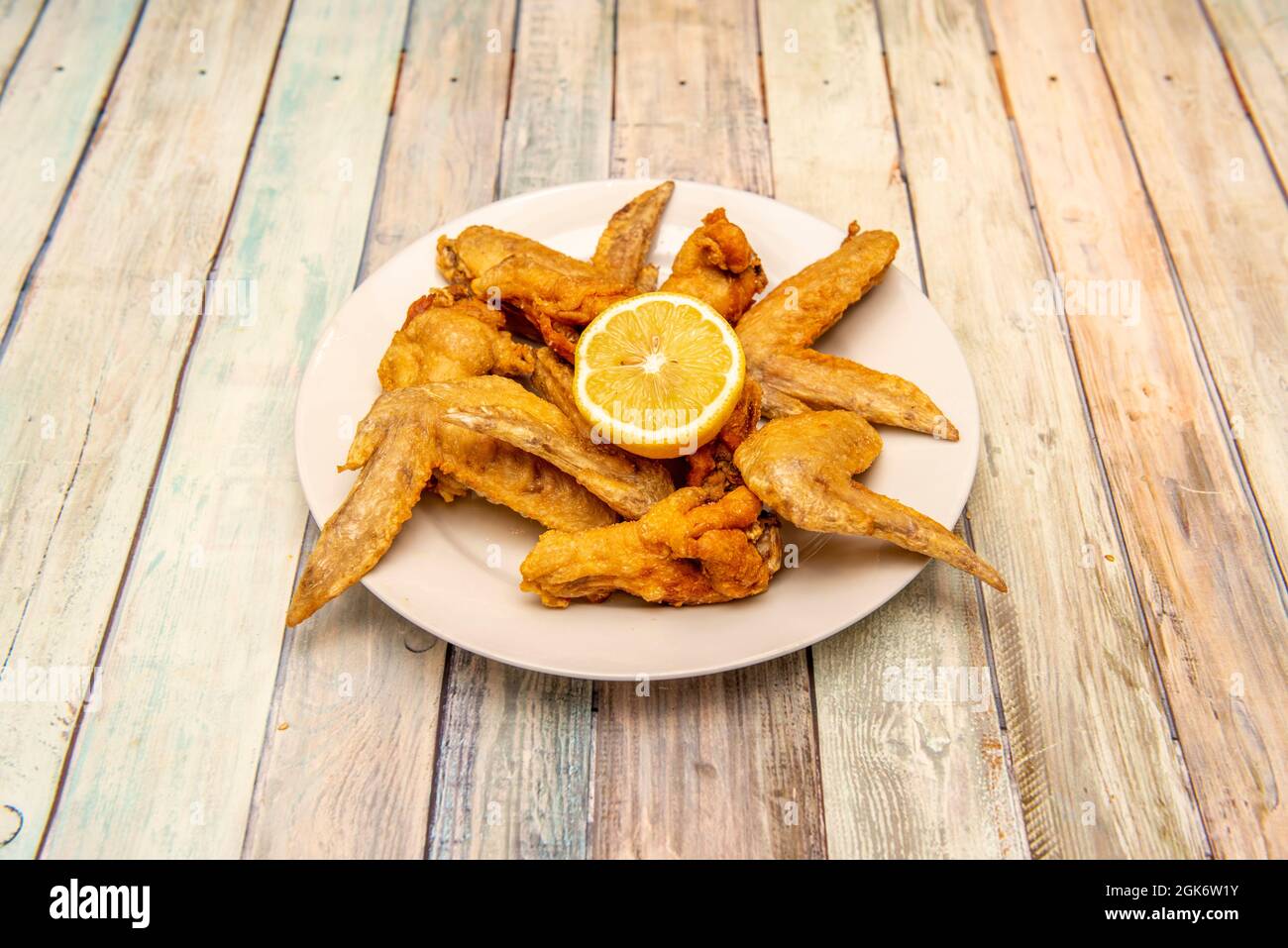 Fried chicken wings in the kitchen of a Spanish tapas restaurant on vintage  wooden table Stock Photo - Alamy