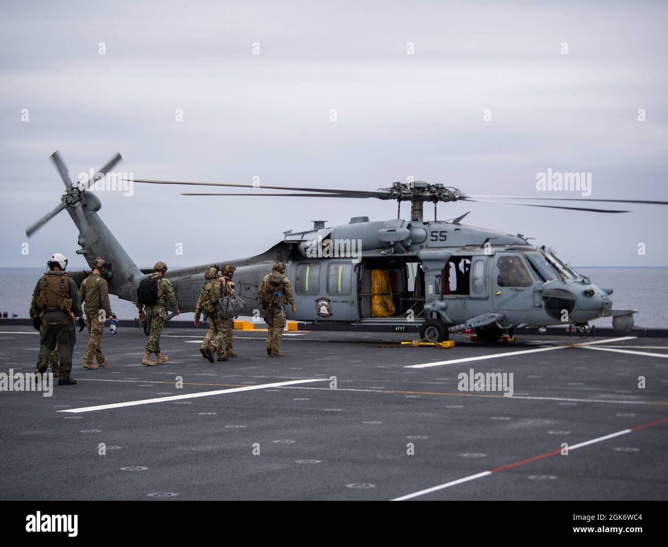 210818-N-WY048-2043  PACIFIC OCEAN (Aug. 18, 2021) –Sailors and Coast Guardsmen board an MH-60S Seahawk, assigned to Helicopter Combat Squadron 23 (HSC 23), aboard expeditionary sea base USS Miguel Keith (ESB 5), Aug. 18. HSC 23 is embarked aboard Miguel Keith conducting routine operations in U.S. 3rd Fleet. Stock Photo