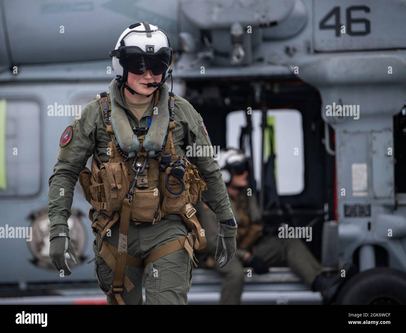 210818-N-WY048-2026  PACIFIC OCEAN (Aug. 18, 2021) – Naval Aircrewman (Helicopter) 3rd Class Ethan Huss, assigned to Helicopter Combat Squadron 23 (HSC 23), prepares to guide passengers onto an MH-60S Seahawk aboard expeditionary sea base USS Miguel Keith (ESB 5), Aug. 18. HSC 23 is embarked aboard Miguel Keith conducting routine operations in U.S. 3rd Fleet. Stock Photo