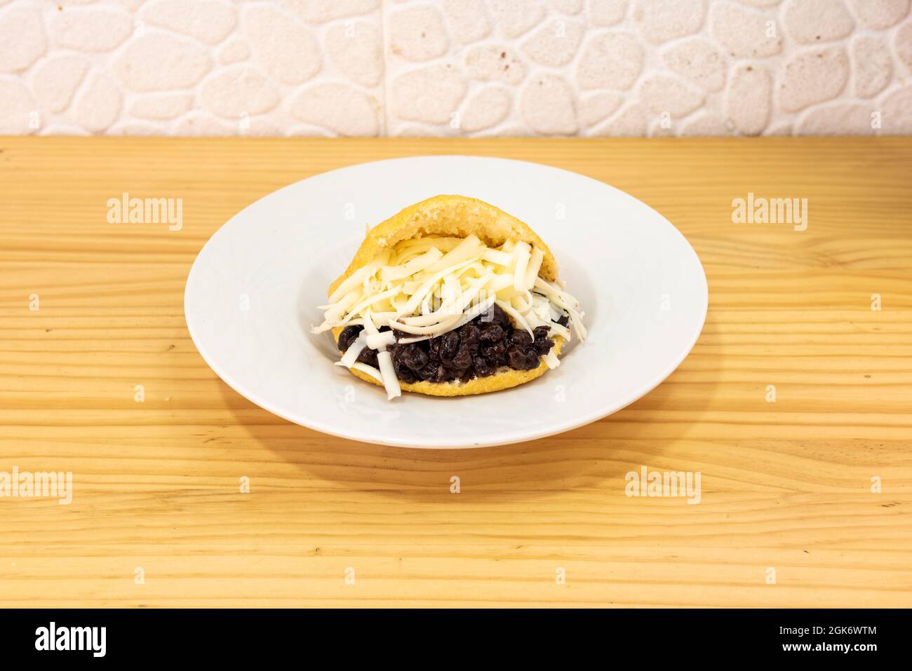Typical Venezuelan arepa domino recipe on yellow background Stock Photo ...