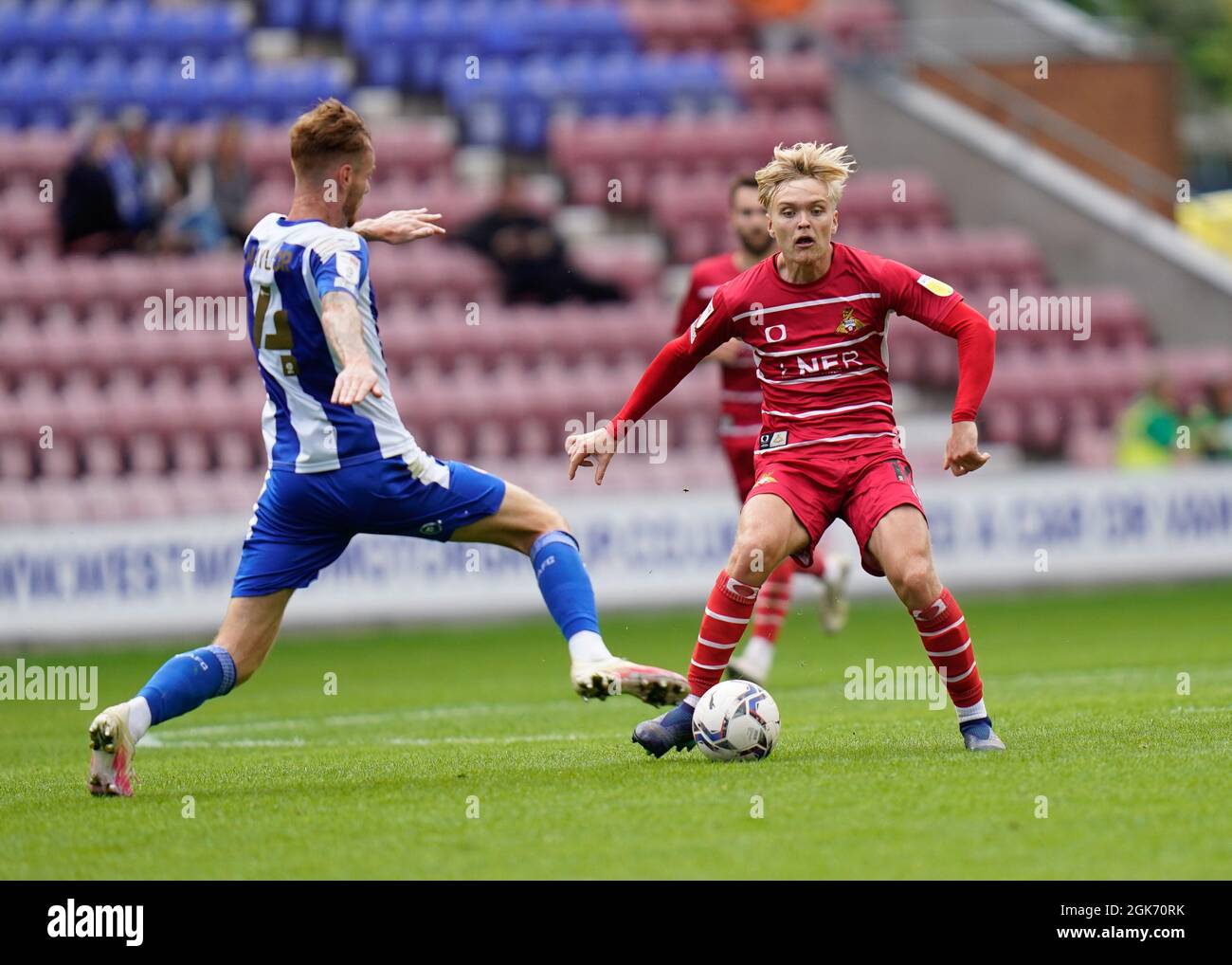 Doncaster's Matthew Smith competes for the ball with Wigan's Tom Naylor during Wigan Athletic -V- Doncaster Rovers   at The DW Stadium, Wigan, Greater Stock Photo