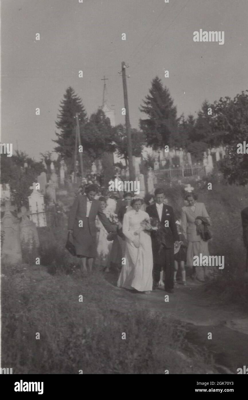 the shortest was was via the cemetery on the other hand it was a rocky road but the priest was waiting in the Church so the photographer gave us this memorable picture: Possibly the world' most grotesque wedding walking from the 1940's Stock Photo