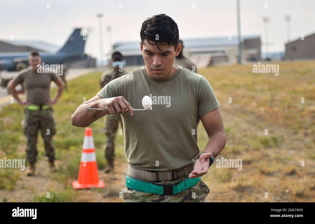 U.S. Air Force Senior Airman Joel N. Perez, 92nd Aircraft Maintenance Squadron Communication Navigation Mission Systems Journeyman, carries an egg on a wrench during an egg relay race at the Maintenance Olympics event at Fairchild Air Force Base, Washington, Aug. 20, 2021. Members from the 92nd Maintenance Squadron, 92nd Aircraft Maintenance Squadron and the 92nd Maintenance Operations Squadron competed and were judged on the collective effort over five events. Stock Photo