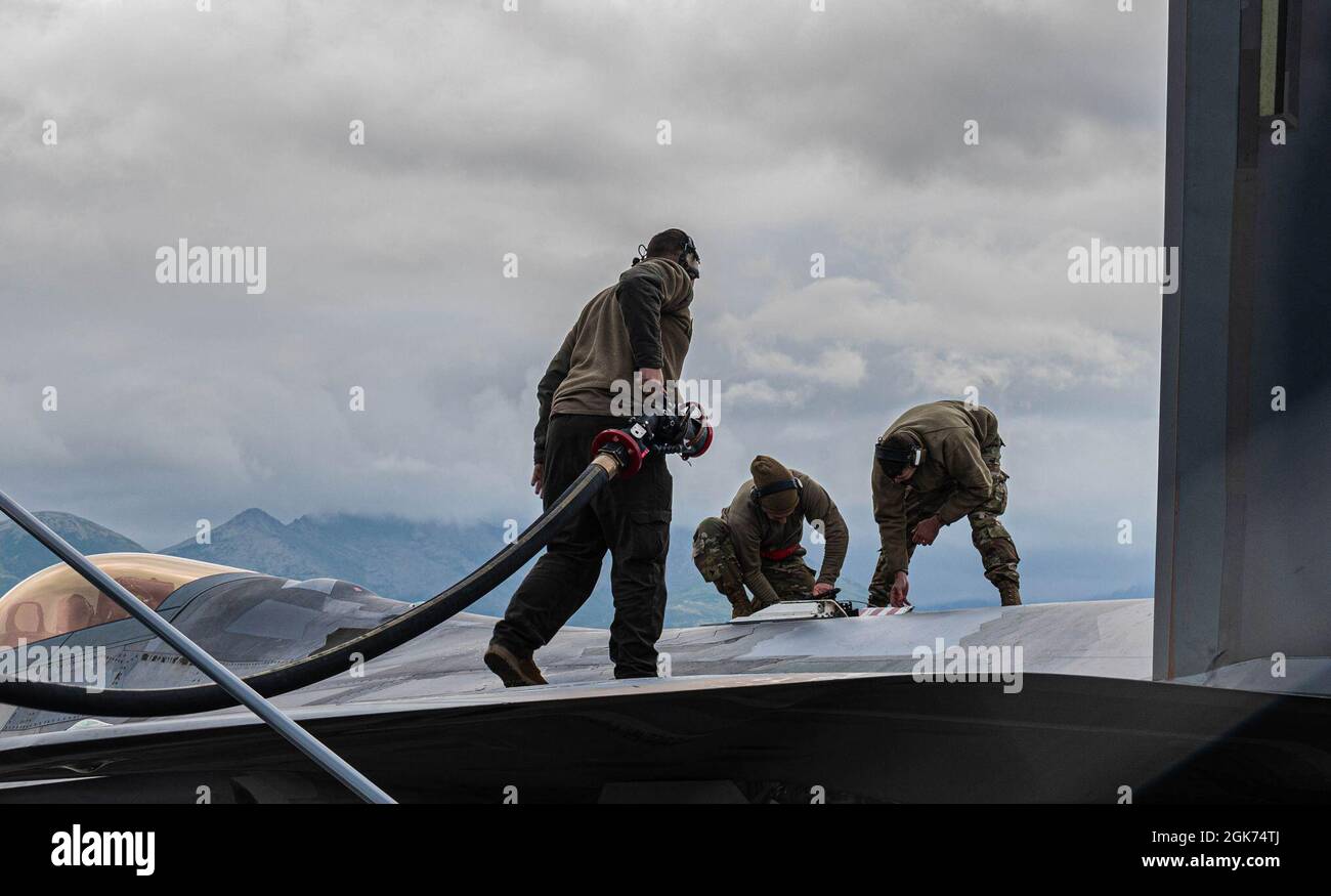 U.S. Air Force aircraft maintainers from the 94th Fighter Squadron service an F-22 Raptor during Red Flag Alaska, 21-3 at Joint Base Elmendorf-Richardson, Alaska, August 20, 2021. Roughly 160 aircraft maintainers from the 1st Fighter Wing, 192nd Wing, and 1st Maintenance Squadron made the trip to Red Flag Alaska to provide maintenance support for the six F-22s participating in this exercise. Stock Photo