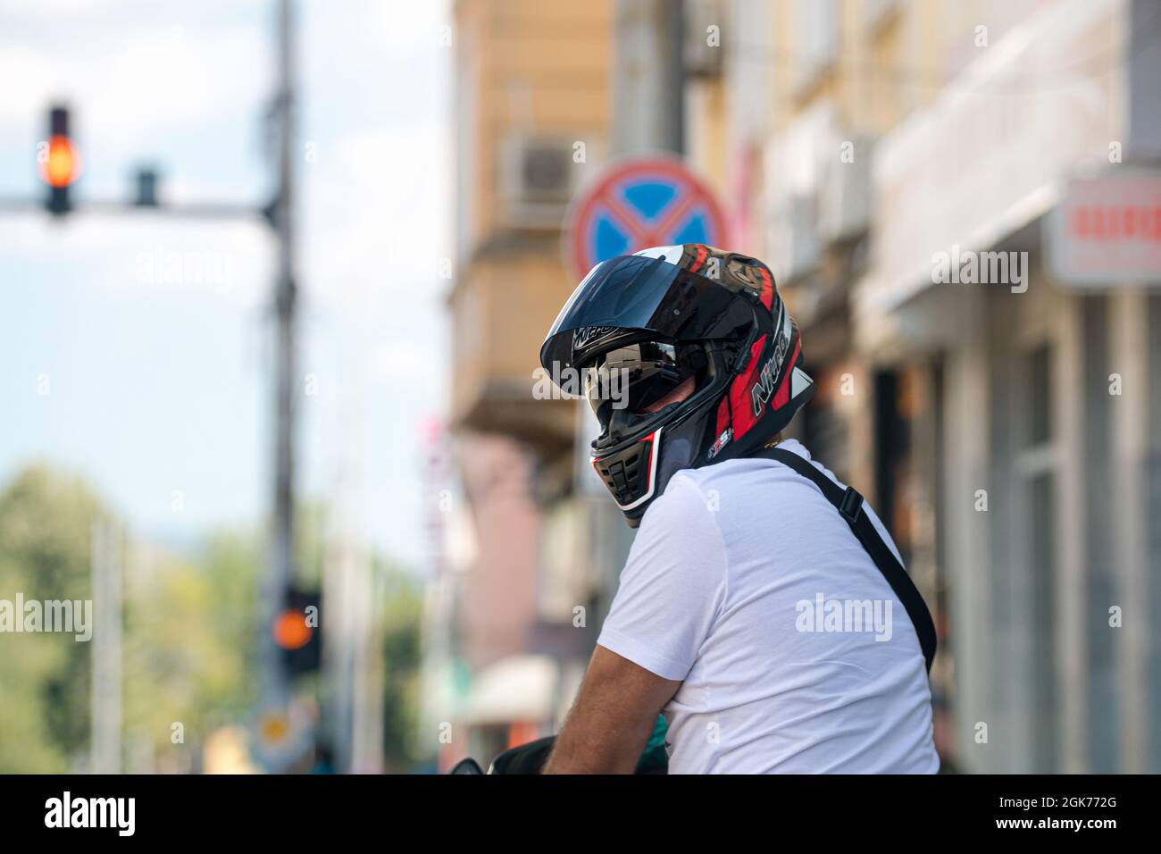 motorcyclist waiting at a traffic light to change to green at a crossroads in the city Stock Photo