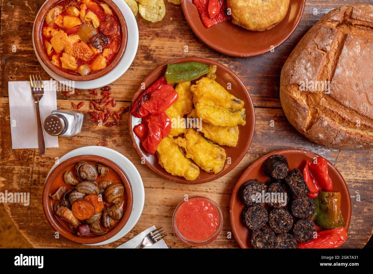 set of dishes with recipes of atavica Spanish food with snails, cod battered with fried peppers, cayenne, tripe, Spanish omelette, fried rice black pu Stock Photo