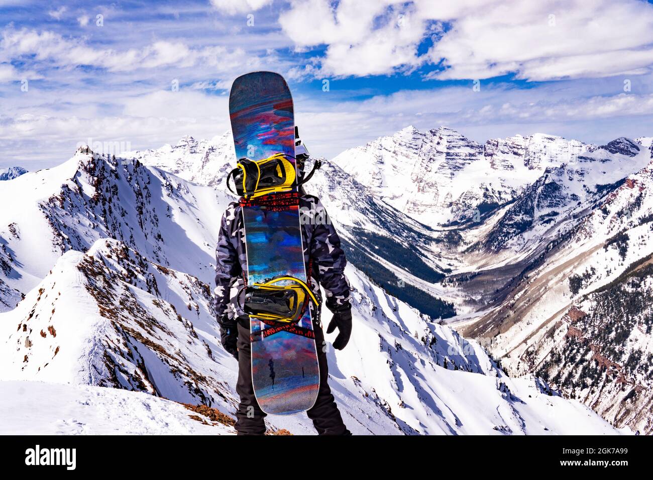 Man With Snow Board On Back In Extreme Snow Mountain Landscape Summit Stock Photo