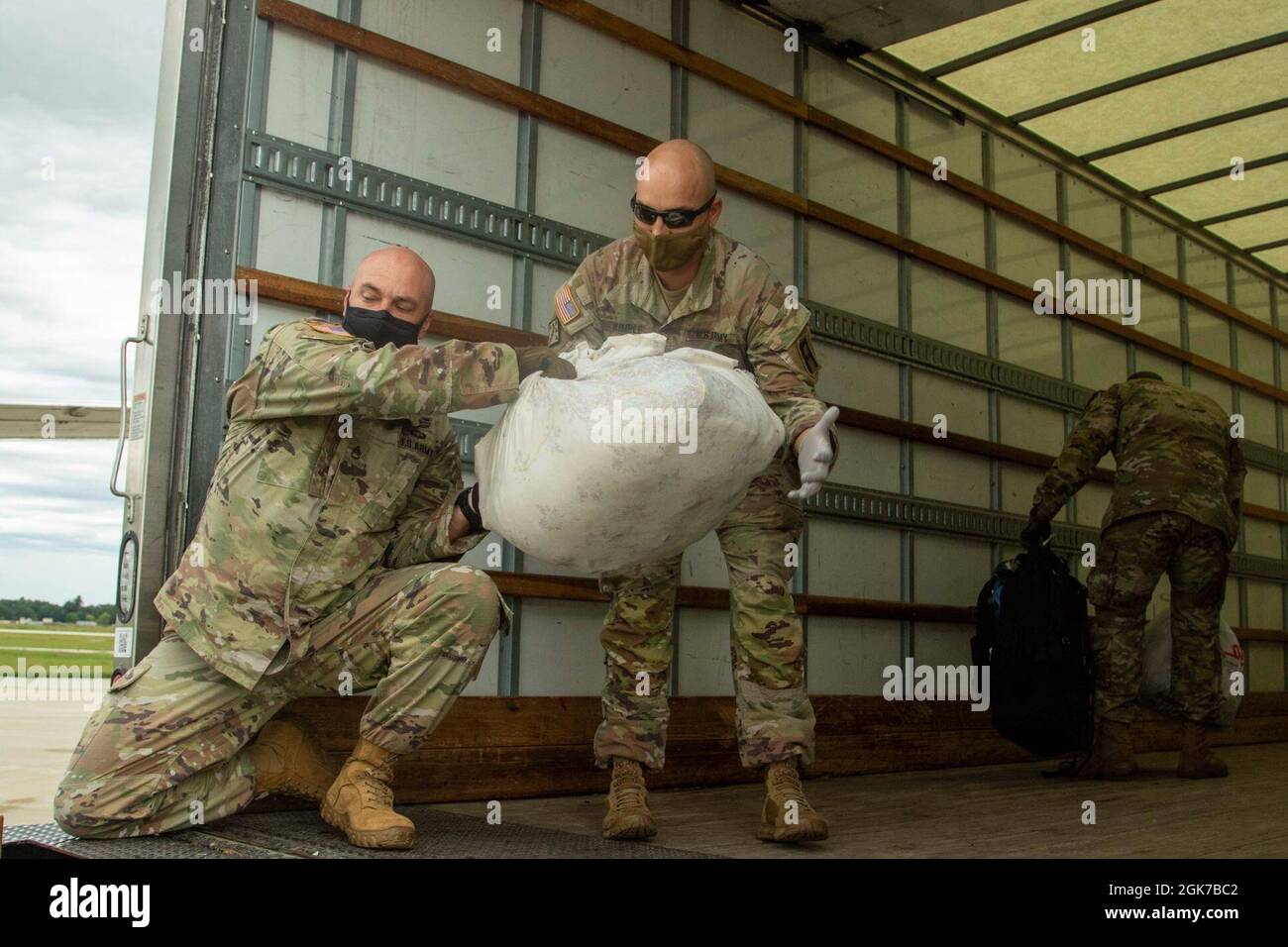 U.S. Army Soldiers assigned to Task Force McCoy assist in loading the
