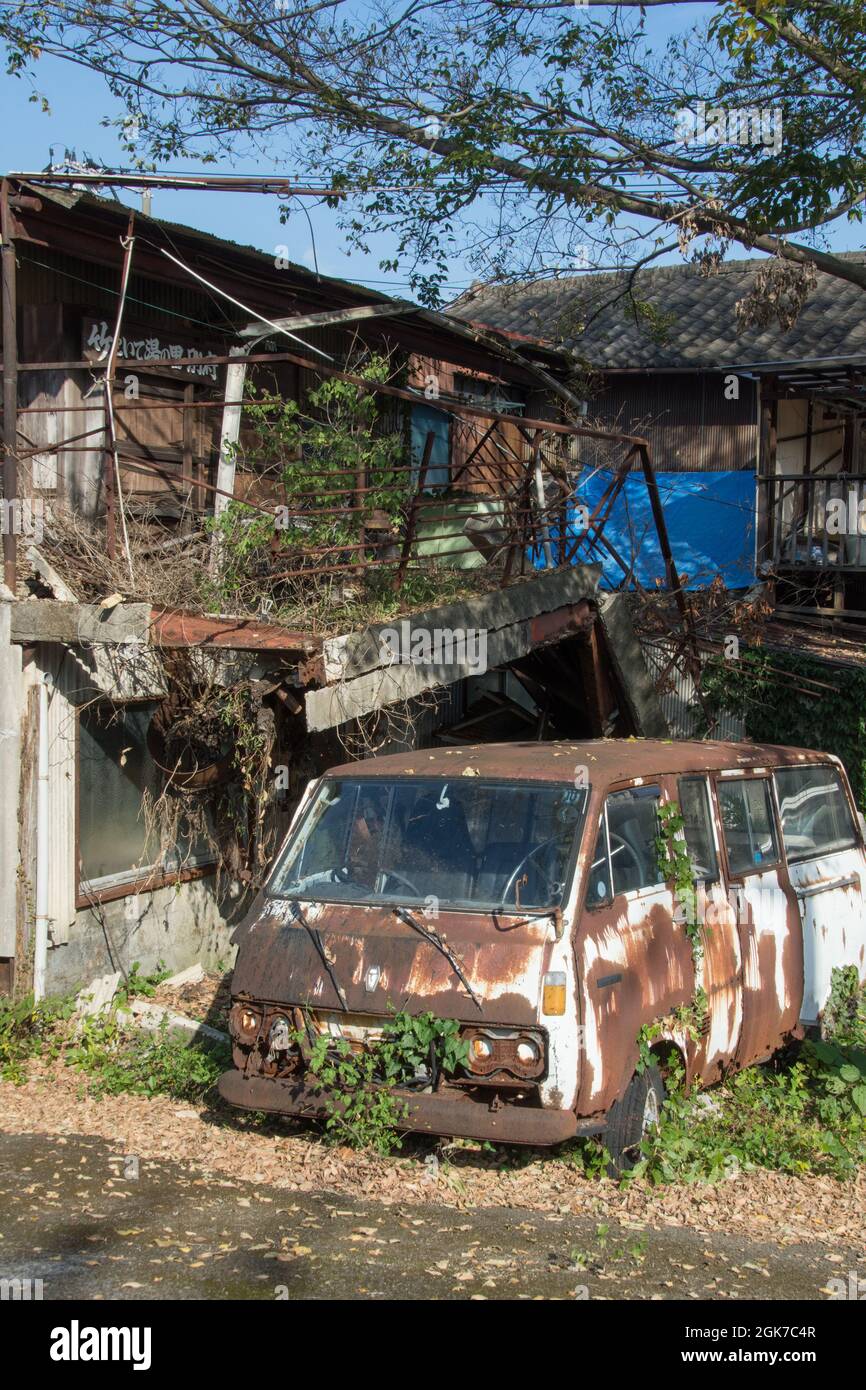 A rusty disused campervan in front of a derelict house, Beppu, Oita Prefecture, Japan, Stock Photo
