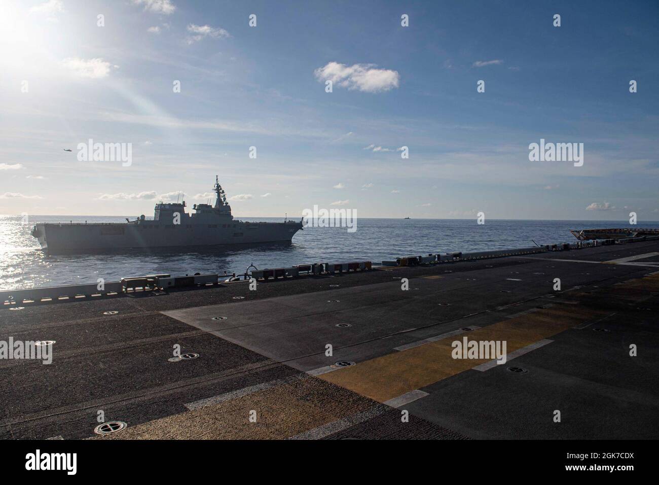 PHILIPPINE SEA (Aug. 24, 2021) The Japan Maritime Self-Defense Force destroyer JS Ise (DD 182) sails in formation with the forward-deployed amphibious assault ship USS America (LHA 6). America, flagship of the America Expeditionary Strike Group, along with the 31st Marine Expeditionary Unit, is operating in the U.S. 7th Fleet area of responsibility to enhance interoperability with allies and partners and serve as a ready response force to defend peace and stability in the Indo-Pacific region. Stock Photo