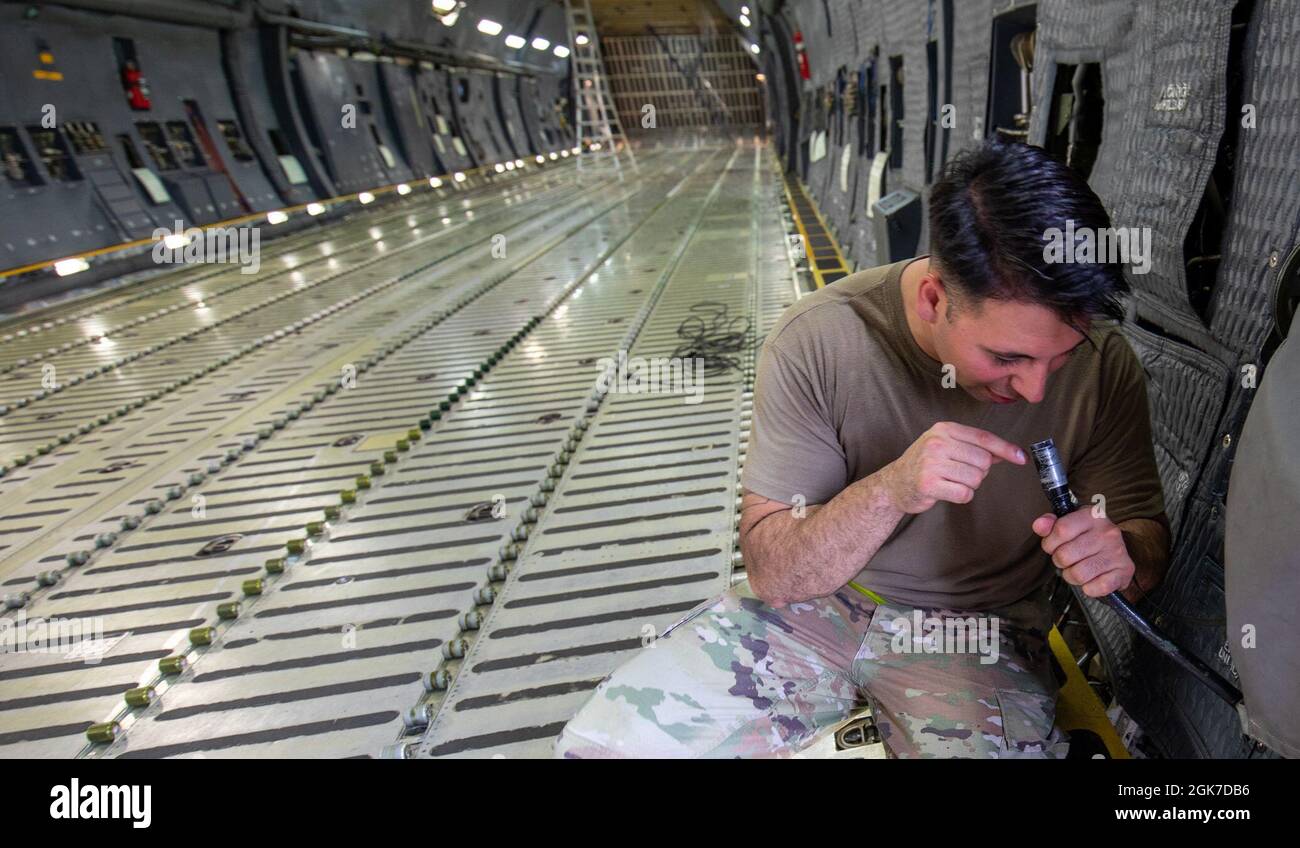 Staff Sgt. Adrian Diaz Jr., 730th Air Mobility Squadron engine shop NCO in charge, checks a fiberscope eyepiece of a C-5M Super Galaxy at Yokota Air Base, Japan, Aug. 24, 2021. C-5M loadmasters use a fiberscope eyepiece for viewing inside the nose landing gear wheel well during a flight. Diaz taught new C-17 Globemaster III crew chiefs how to inspect, service, turn on electrical power and investigate systems of a C-5M. The 730th AMS’ crew chiefs can conduct inbound C-17 Globemaster III and C-5M Super Galaxy aircraft maintenance 24/7. Stock Photo