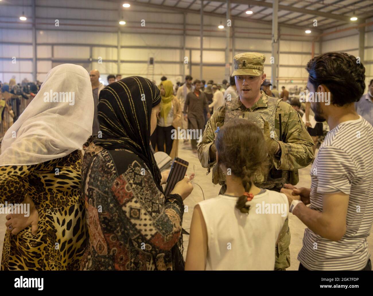 An airman provides assistance to qualified evacuees at Al Udeid Air Base,  Qatar, Aug. 26, 2021. The Department of Defense is committed to supporting  the evacuation of American citizens, Special Immigrant Visa