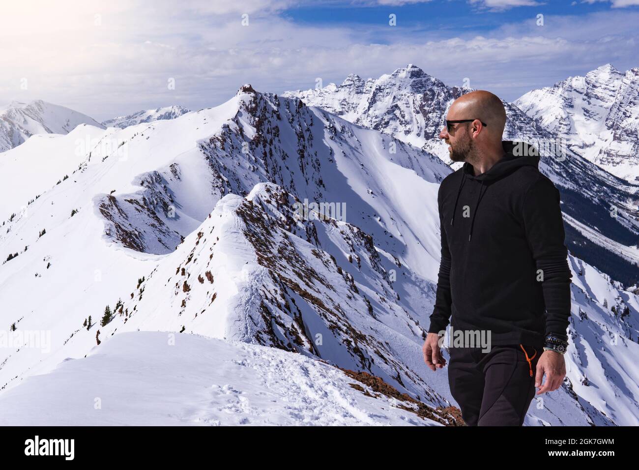 Bald Male Model In Winter Exploration On Snow Covered Mountain Peak Stock Photo