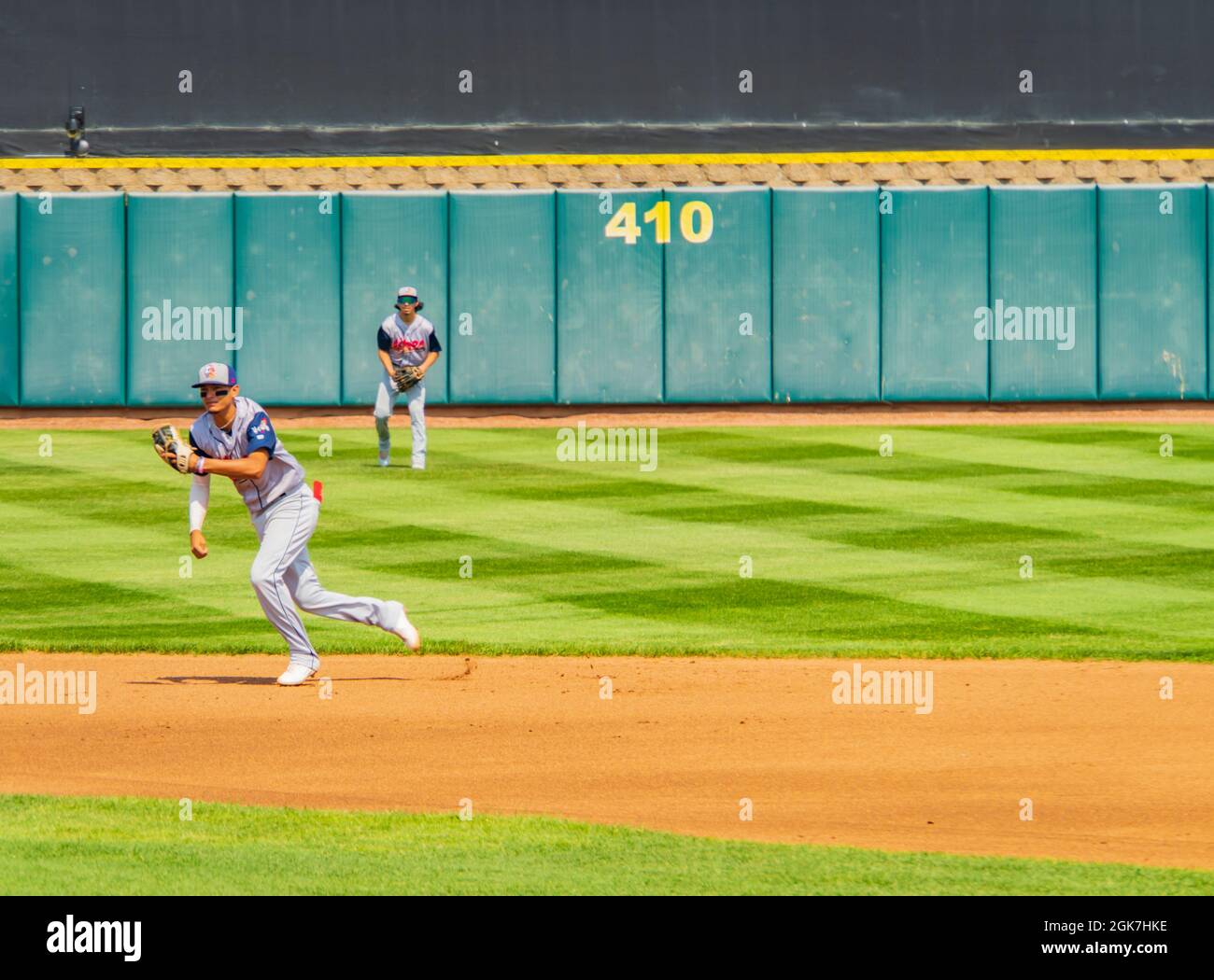 baseball players running to catch the ball Stock Photo