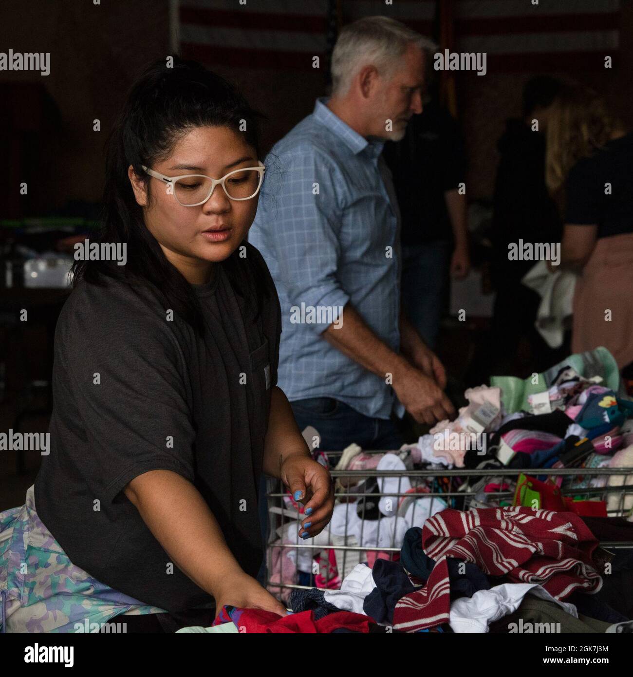 Xuenja Allison, military spouse, organizes donated clothing at Ramstein