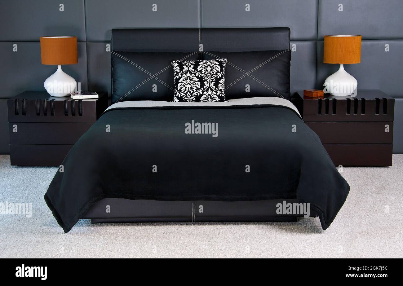 Bed, gray bedroom, lamp,  bureau, coverlet, blanket Stock Photo