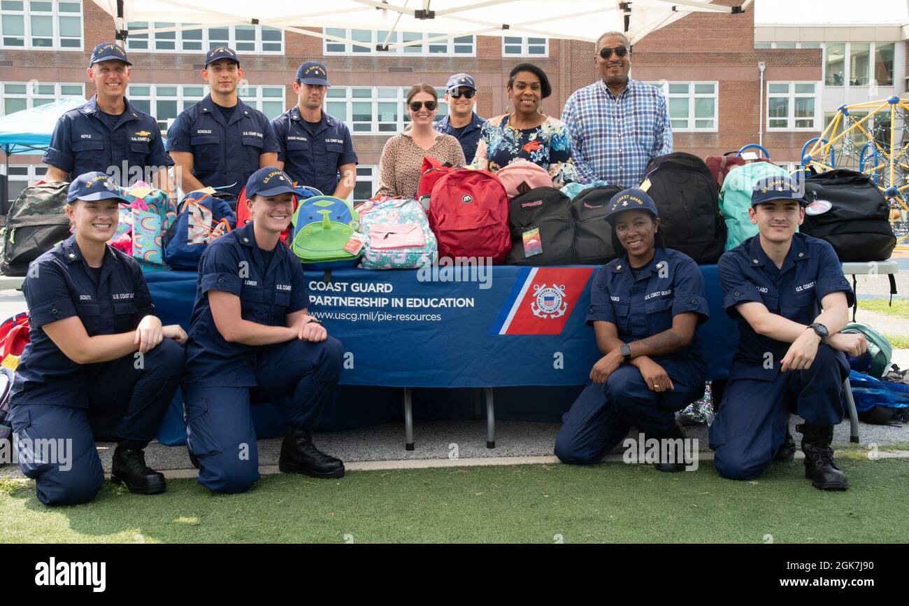 Chaplain Andrew Hoyle (standing, back left), CGHQ Partnership In Education (PIE) Coordinator, along with USCG and DHS volunteers, pose in front of a table full of backpacks stuffed with school supplies at Anita J. Turner Elementary School during a back-to-school night event on Thursday, August 26th. Hundreds of USCG and DHS volunteers donated equipment or helped pack backpacks with schools supplies to support the D.C. community through St. Elizabeth’s Back-to-School backpack and supply drive. This year, the annual drive was part of the Coast Guard's Partnership in Education Program. Stock Photo