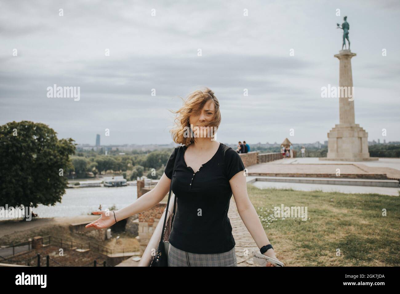 Beautiful Bosnian female posing against the Victor sculpture in Belgrade, Serbia Stock Photo