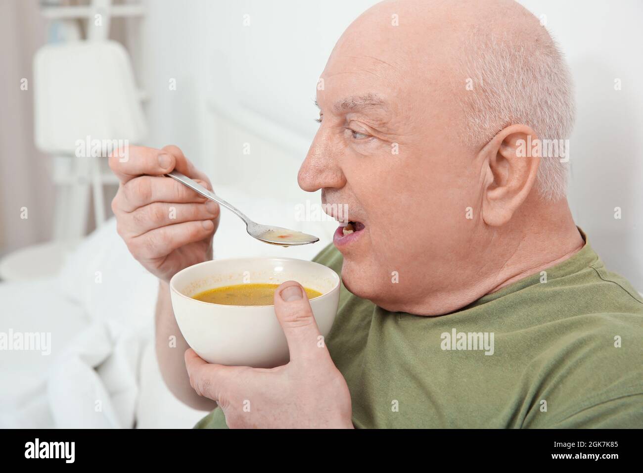 Elderly man eating soup in bed Stock Photo Alamy