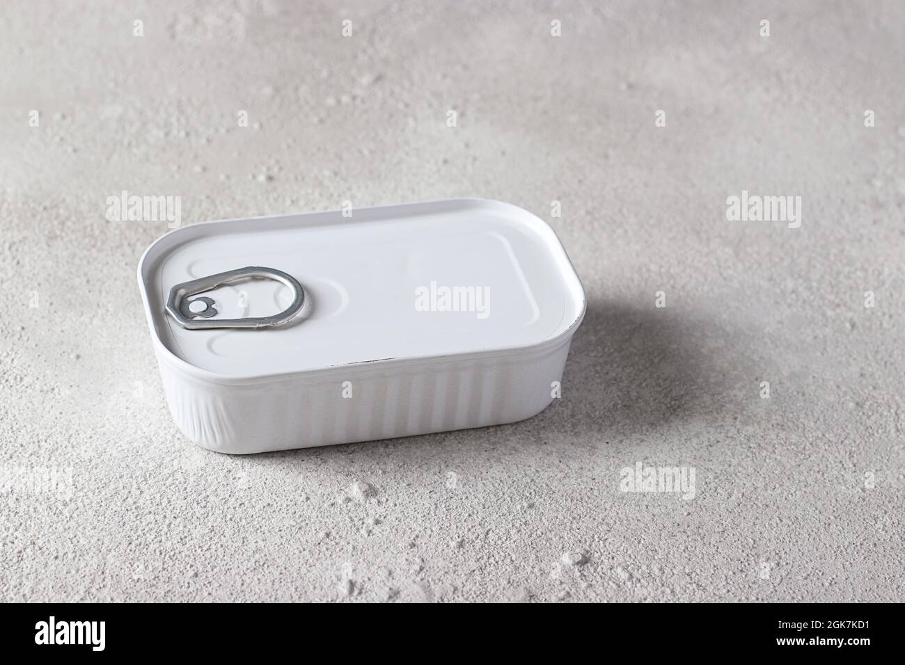 Cod liver in an white tin can on light gray background. Horizontal format. Stock Photo