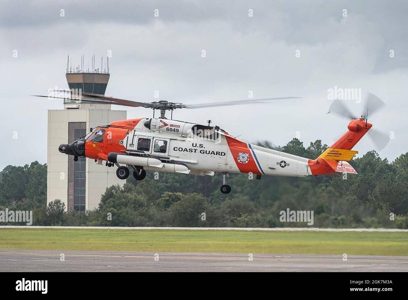 An MH-60 Jayhawk helicopter crew conduct a training flight at Aviation Training Center Mobile in Alabama on Aug. 27, 2021, ahead of Hurricane Ida. Coast Guard crew prepare and relocate aircraft out of the main path of the storm to be ready to respond as soon as the worst passes. Stock Photo