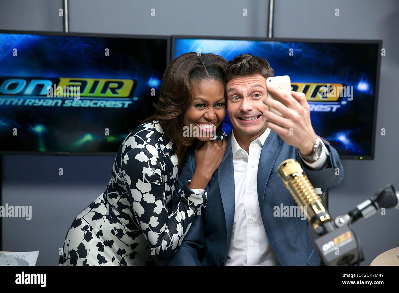 First Lady Michelle Obama poses for a selfie with Ryan Seacrest after taping a 'Let's Move!' interview at E! Networks in Los Angeles, Calif., Jan. 29, 2014. (Official White House Photo by Lawrence Jackson) This official White House photograph is being made available only for publication by news organizations and/or for personal use printing by the subject(s) of the photograph. The photograph may not be manipulated in any way and may not be used in commercial or political materials, advertisements, emails, products, promotions that in any way suggests approval or endorsement of the President, t Stock Photo