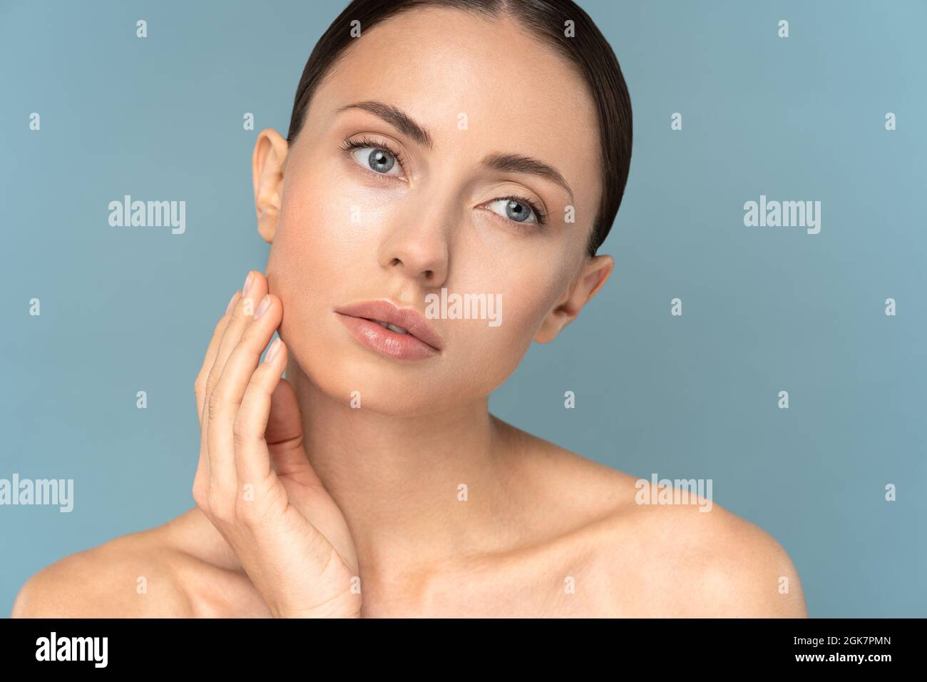 Young woman with natural makeup, combed hair, touching well-groomed ...