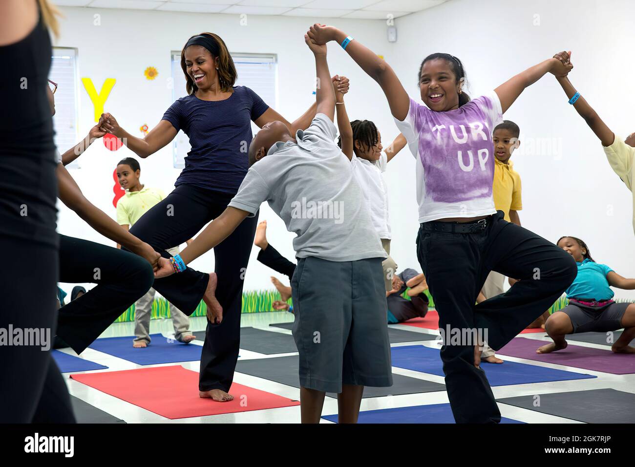 First Lady Michelle Obama joins children for a yoga class during a 'Let's Move!' after school activities event at Gwen Cherry Park in Miami, Fla., Feb. 25, 2014. (Official White House Photo by Amanda Lucidon) This official White House photograph is being made available only for publication by news organizations and/or for personal use printing by the subject(s) of the photograph. The photograph may not be manipulated in any way and may not be used in commercial or political materials, advertisements, emails, products, promotions that in any way suggests approval or endorsement of the President Stock Photo