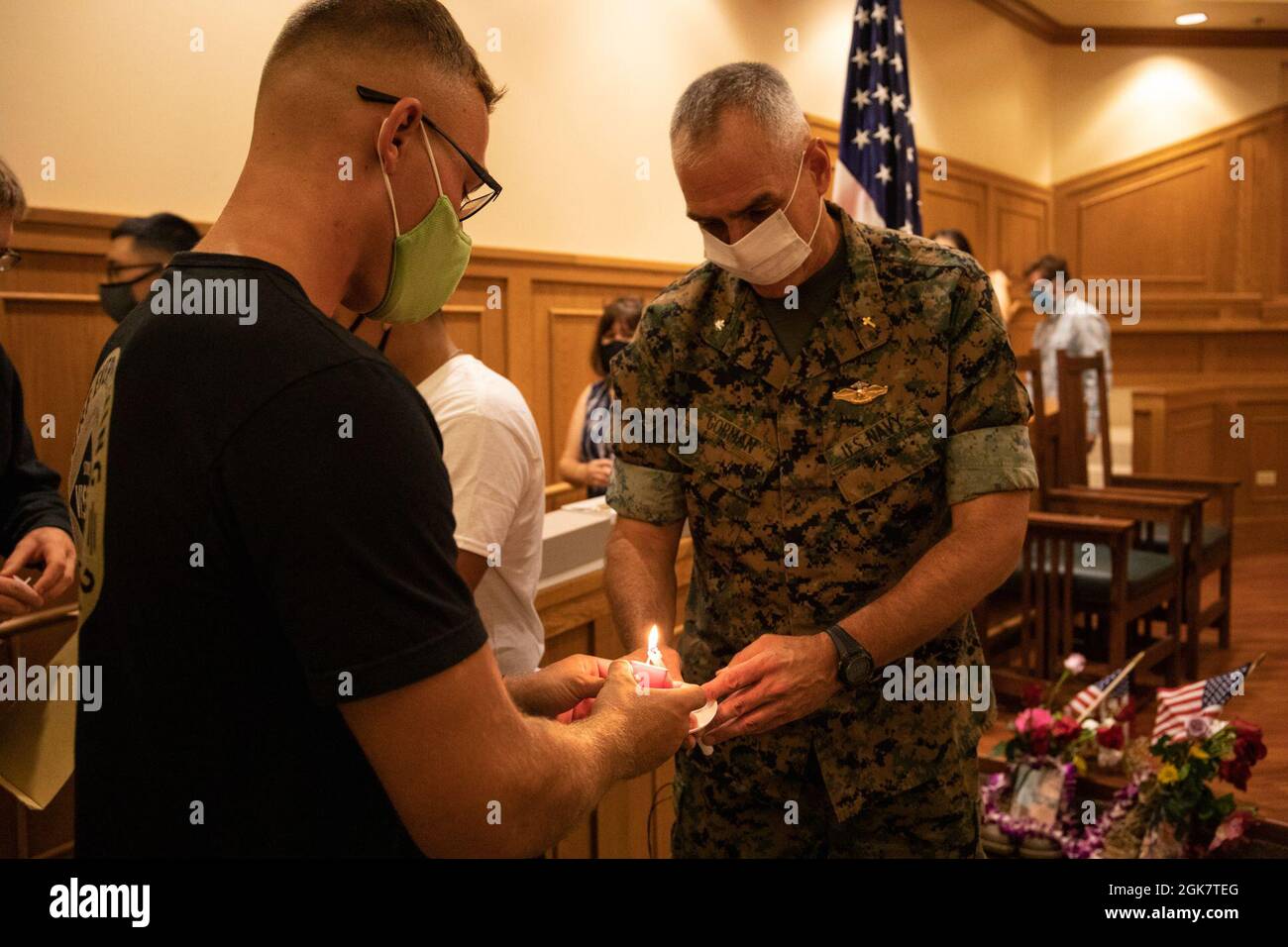 U.S. Navy Cmdr. Edward M. Gorman, right, base chaplain, Marine Corps Base Hawaii, assists in