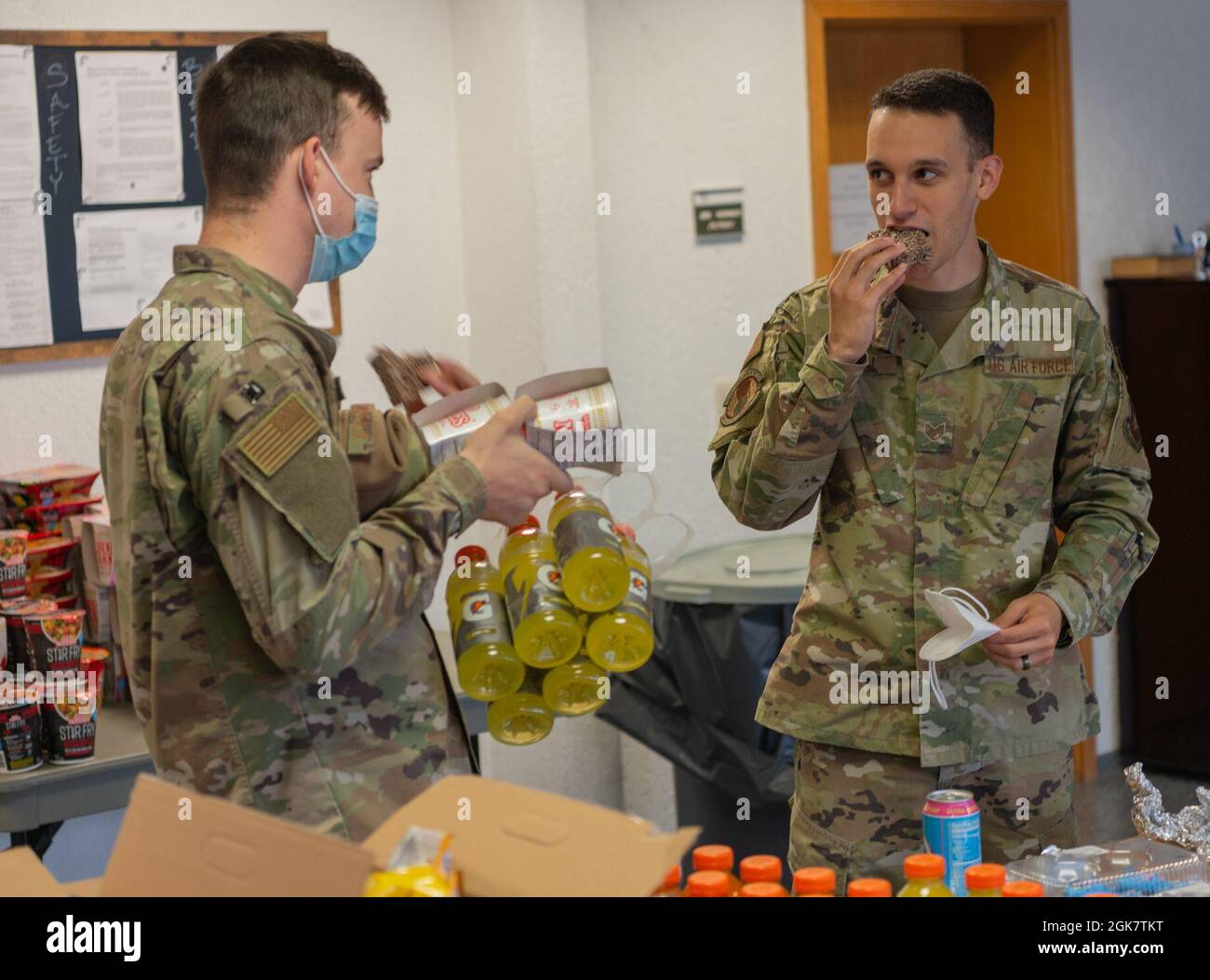 U.S. Air Force Staff Sgt. Johsua Micell,  86th Logistics Readiness Squadron facility supervisor, right, and Senior Airman Austin Boudreaux, 86th LRS fixed facility operator, grab food at the south side chapel at Ramstein Air Base, Germany, Aug. 30, 2021. The southside chapel has provided Airmen with food, water, entertainment and a quiet place to rest after a long day of work. Stock Photo