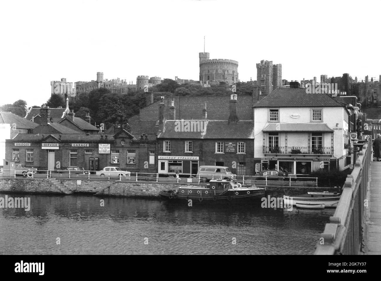 1960s, historical, taken from Windsor Bridge, we see a view of Thames Side, a street by the river Thames in the historic town of Windsor, Berkshire, England, UK. The riverside town is famous for it's historic castle - seen on the skyline in the distance - a residence of the British Royal family for over 1,000 years. Salters Steamers, who offices can be seen, were established in 1858 and operated pleasure trips up and down the river. Stock Photo