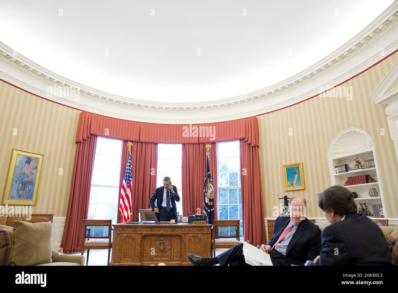 President Barack Obama talks on the phone with President Vladimir Putin of Russia in the Oval Office, March 1, 2013. National Security Advisor Tom Donilon speaks with Tony Blinken, Deputy National Security Advisor, right. (Official White House Photo by Pete Souza) This official White House photograph is being made available only for publication by news organizations and/or for personal use printing by the subject(s) of the photograph. The photograph may not be manipulated in any way and may not be used in commercial or political materials, advertisements, emails, products, promotions that in a Stock Photo
