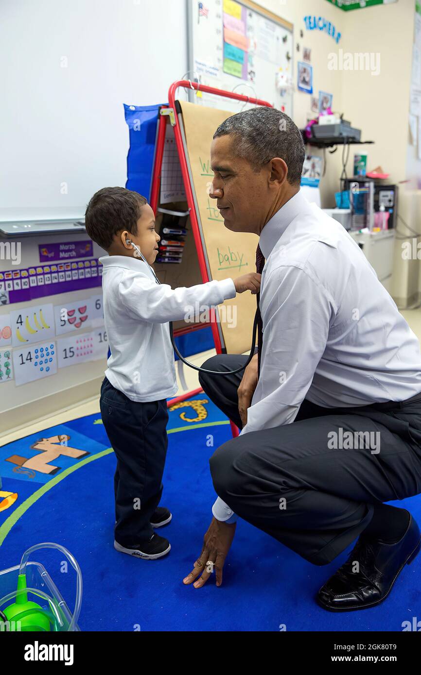 President Barack Obama lets a little boy listen to his heartbeat with a stethoscope during a classroom visit at Powell Elementary School in Washington, D.C., March 4, 2014. (Official White House Photo by Pete Souza) This official White House photograph is being made available only for publication by news organizations and/or for personal use printing by the subject(s) of the photograph. The photograph may not be manipulated in any way and may not be used in commercial or political materials, advertisements, emails, products, promotions that in any way suggests approval or endorsement of the Pr Stock Photo