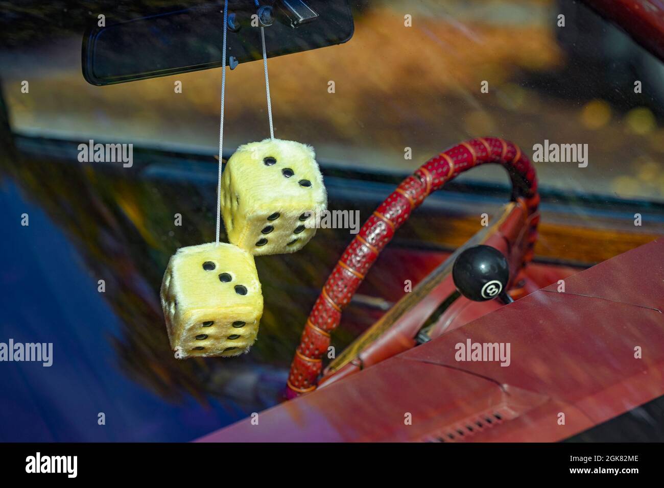 Furry dice hanging from car rear view mirror Stock Photo