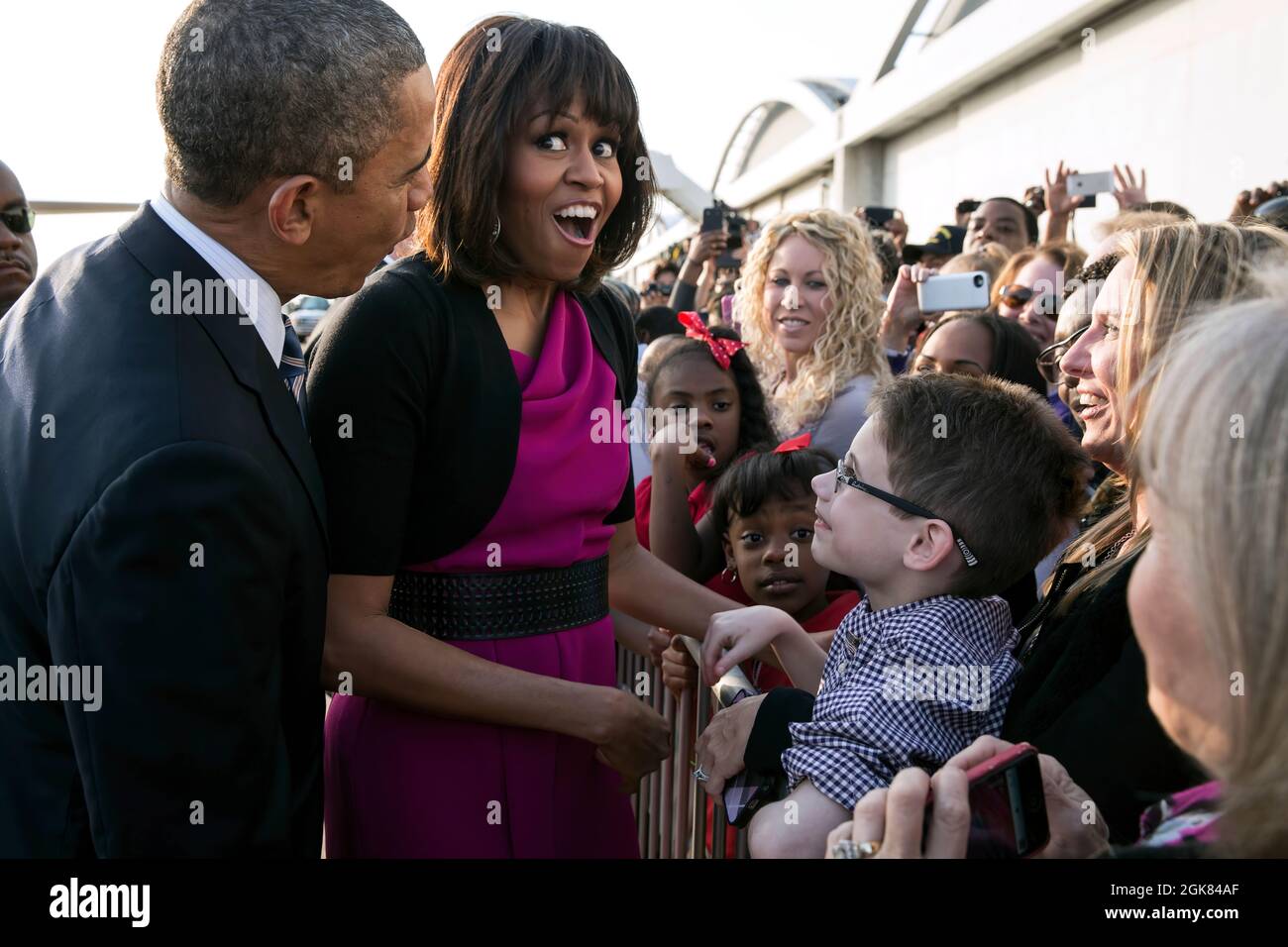 First Lady Michelle Obama reacts after President Barack Obama quieted a baby along a ropeline at Love Field Airport in Dallas, Texas, April 24, 2013. (Official White House Photo by Pete Souza)  This official White House photograph is being made available only for publication by news organizations and/or for personal use printing by the subject(s) of the photograph. The photograph may not be manipulated in any way and may not be used in commercial or political materials, advertisements, emails, products, promotions that in any way suggests approval or endorsement of the President, the First Fam Stock Photo