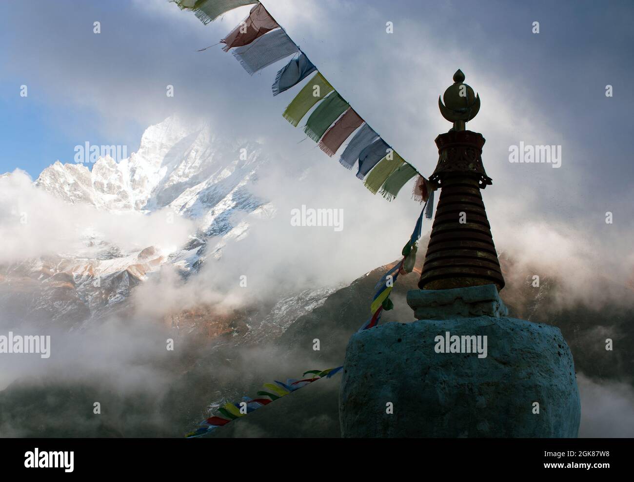 Buddhist Stupa with prayer flags and Thamserku peak - Trek to Everest base camp - Nepal Stock Photo