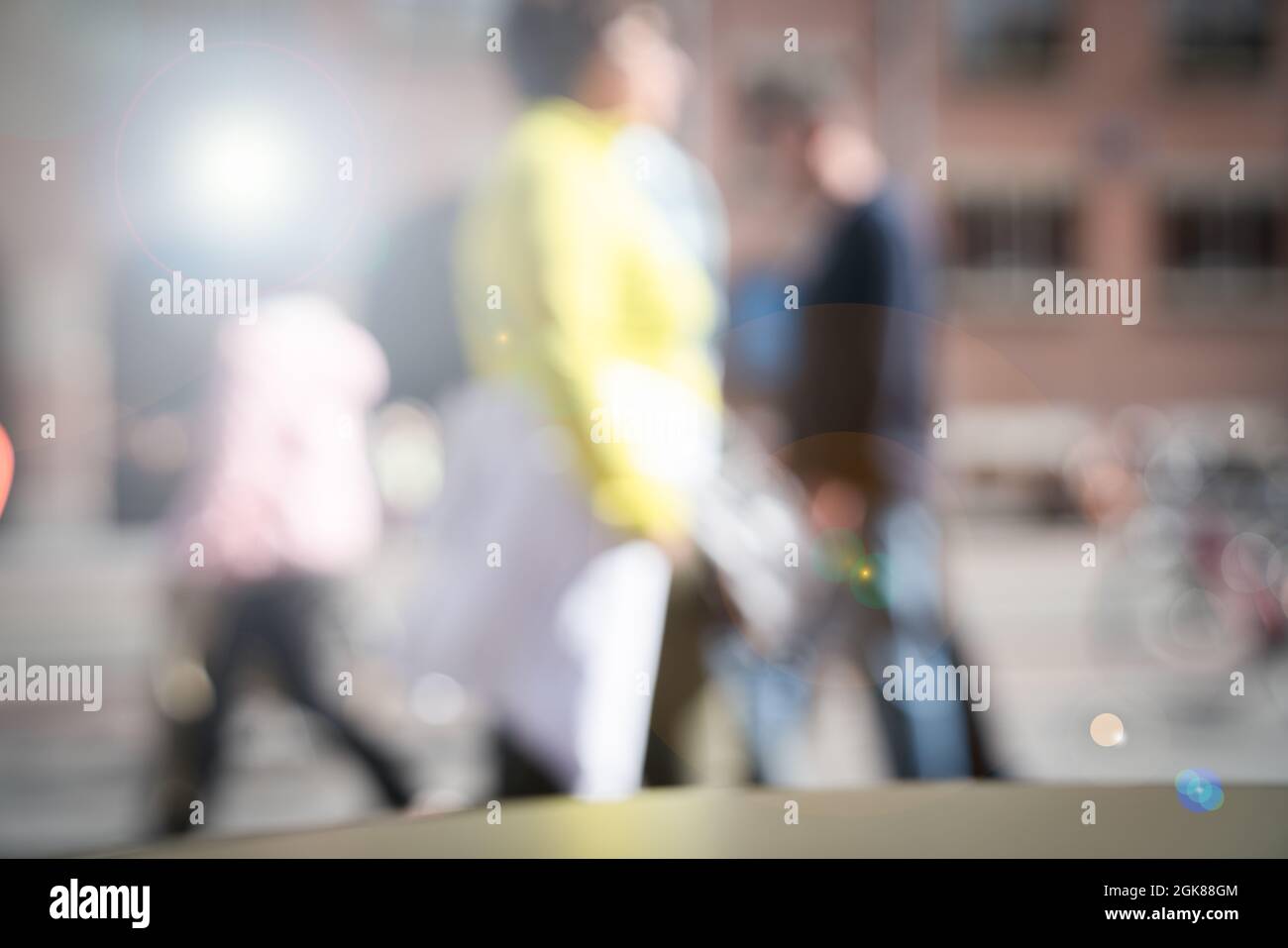 Busy city street with people blurred in motion walking past as ...