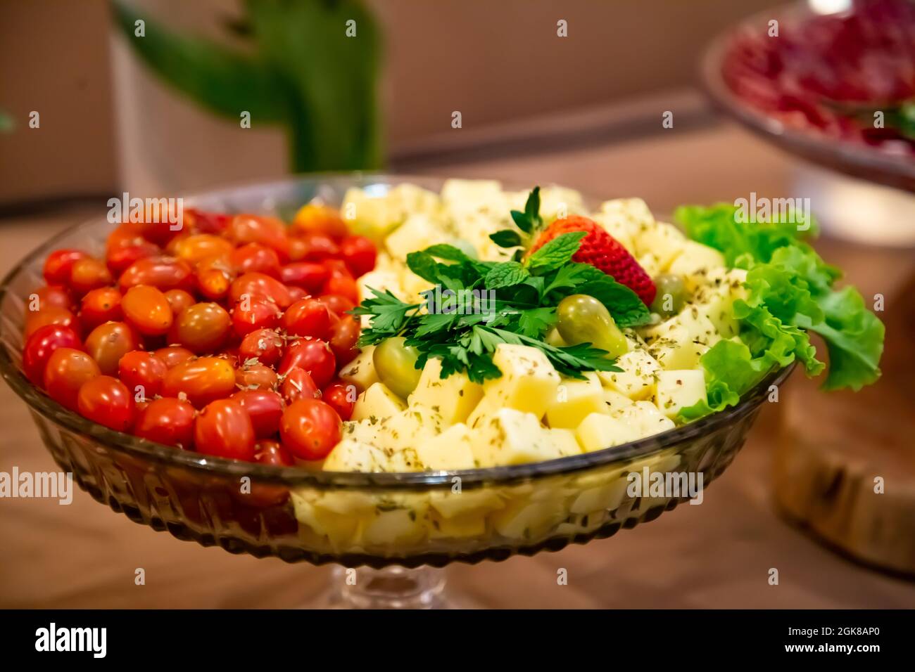 Vasilha com tomates, queijos e azeitonas. Grande variedade de comida organizada em uma mesa de buffet festiva. Stock Photo