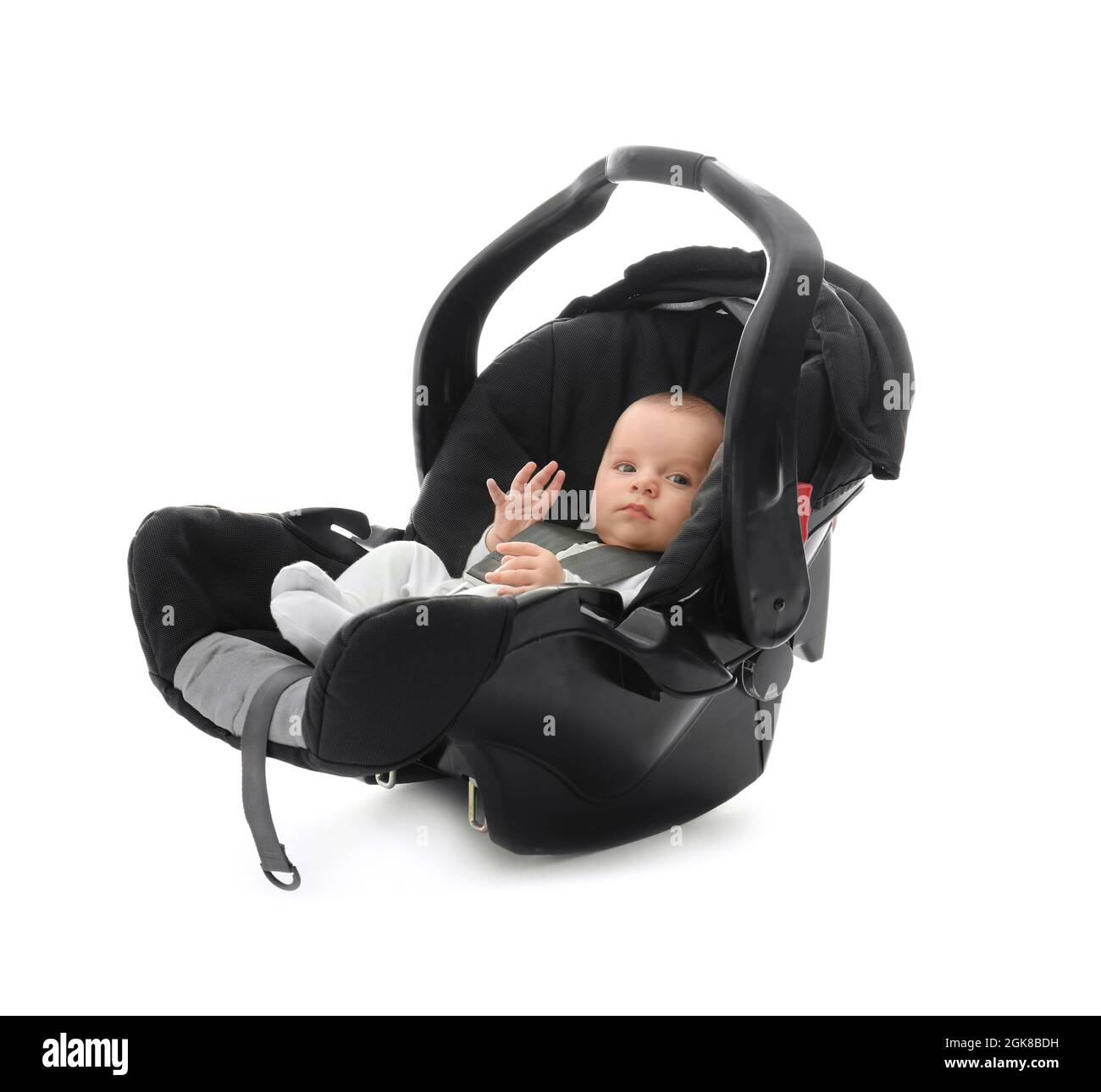 Adorable baby boy sitting in car seat with safety belt on white
