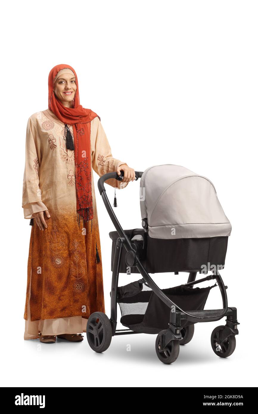 Full length shot of a young woman in ethnic clothes standing with a baby stroller isolated on white background Stock Photo