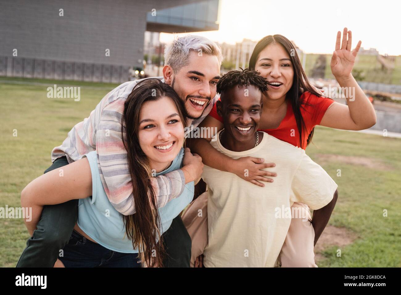 Young diverse people having fun together outdoor at city park - Focus on left girl face Stock Photo