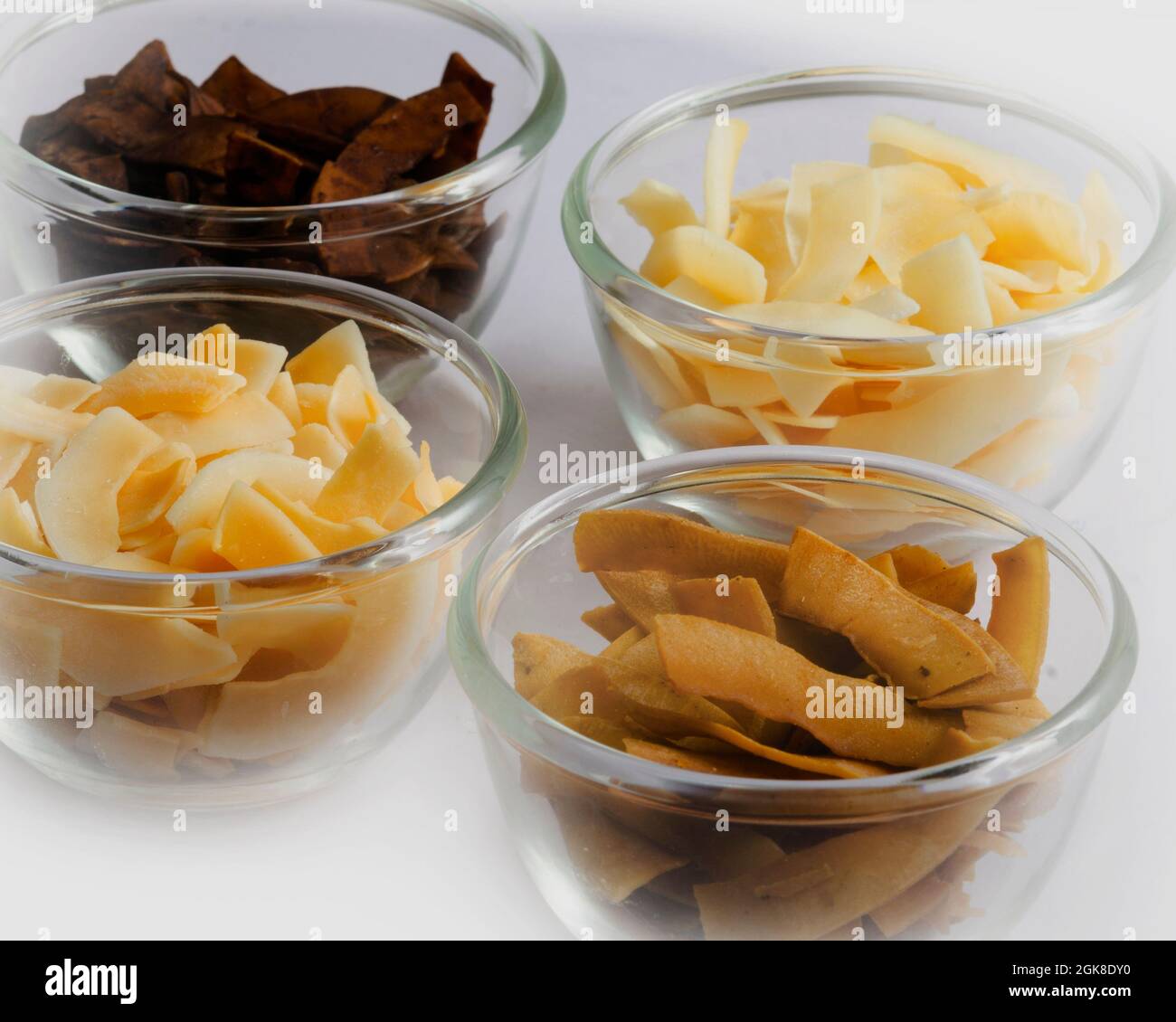 Toasted Coconut Chips flakes. Different flavors in white bowls Stock