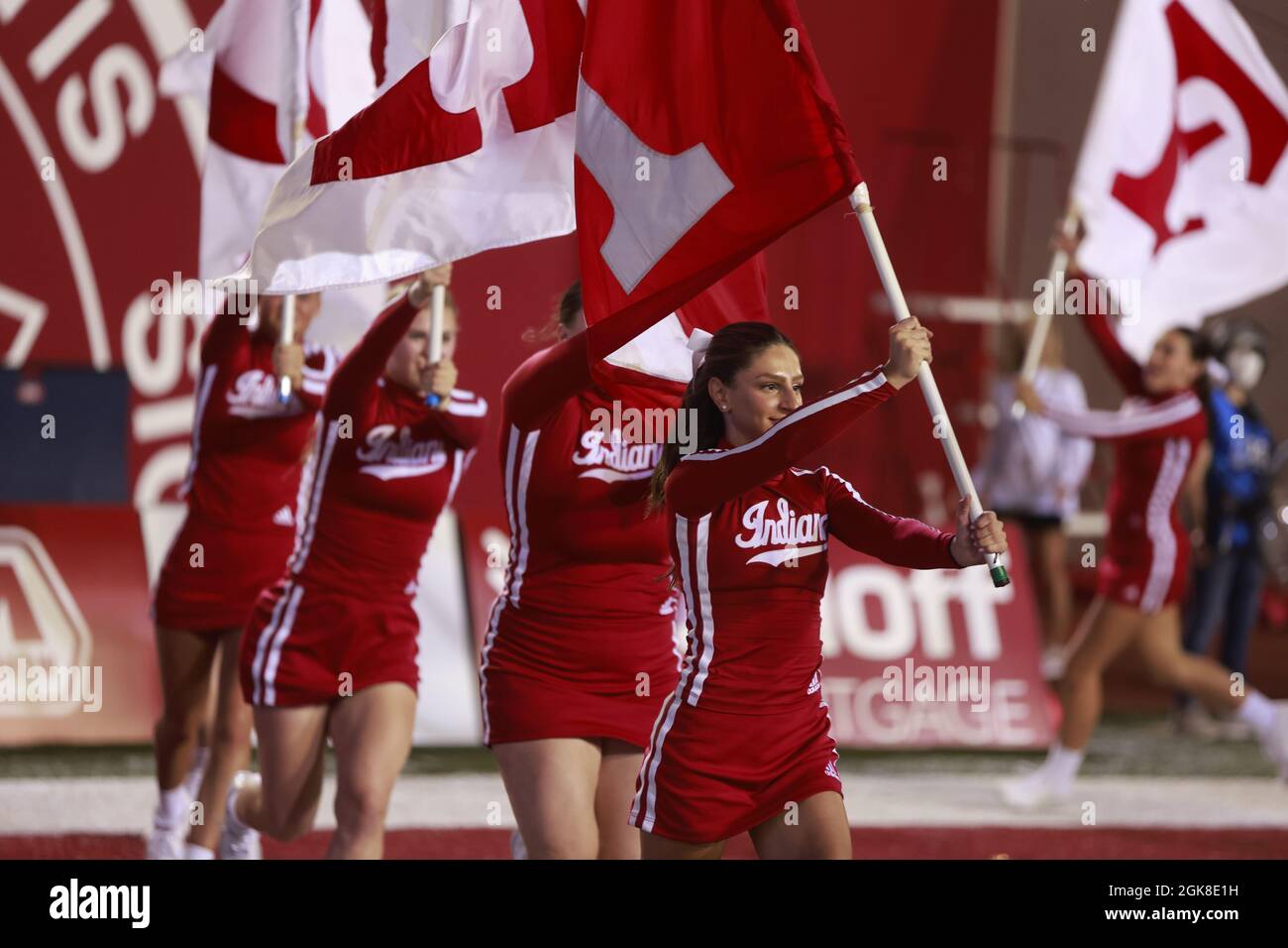 BLOOMINGTON, UNITED STATES - 2021/09/11: Indiana University cheerleaders carry flags after IU scores against Idaho during an NCAA football game on September 11, 2021 at Memorial Stadium in Bloomington, Ind. The Hoosiers beat the Vandals 56-14. Stock Photo